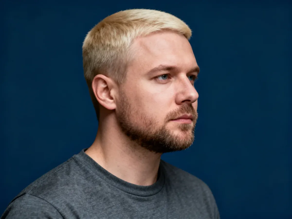 Mężczyzna z precyzyjnie przystrzyżonymi włosami w stylu crew cut, prezentujący klasyczną i schludną fryzurę.