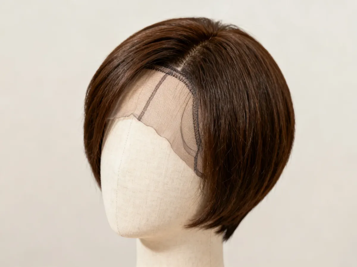 Krótka naturalna peruka na manekinie z widocznym czepkiem mono i lace front