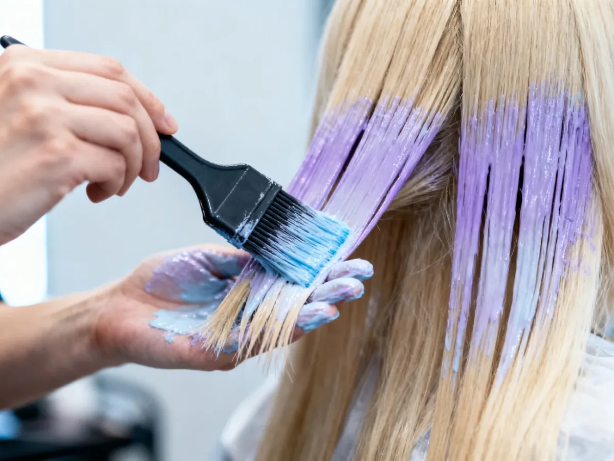 Fryzjer nakładający chłodny toner na blond włosy